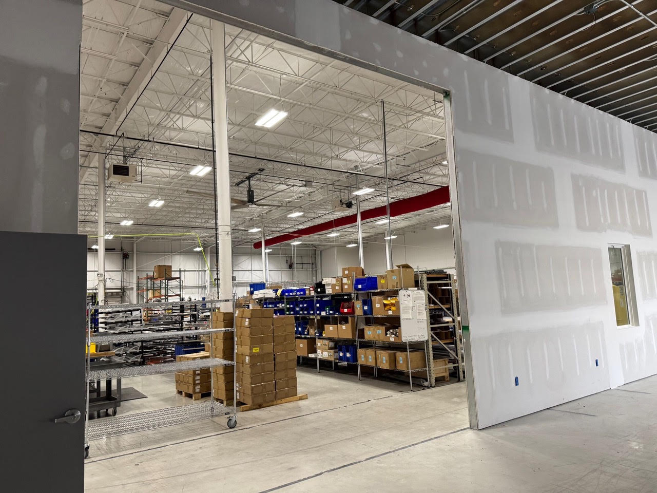 A large opening in a new taped wall, looking out to the Teknoware warehouse racking